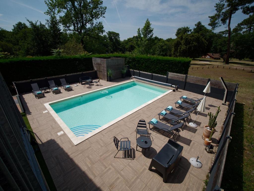 an overhead view of a swimming pool with lounge chairs at Hotel Au Bon Coin du Lac in Mimizan