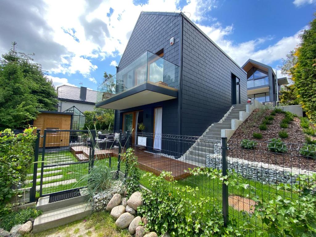 a black house with a garden in front of it at Grafit in Mechelinki