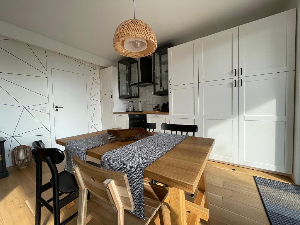 a kitchen with a wooden table and white cabinets at Grafit in Mechelinki