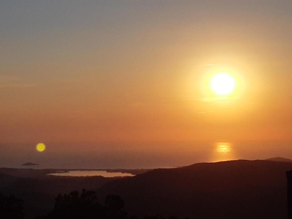 um pôr-do-sol sobre o oceano com o sol no céu em ALBA MOZZAFIATO em Lanusei