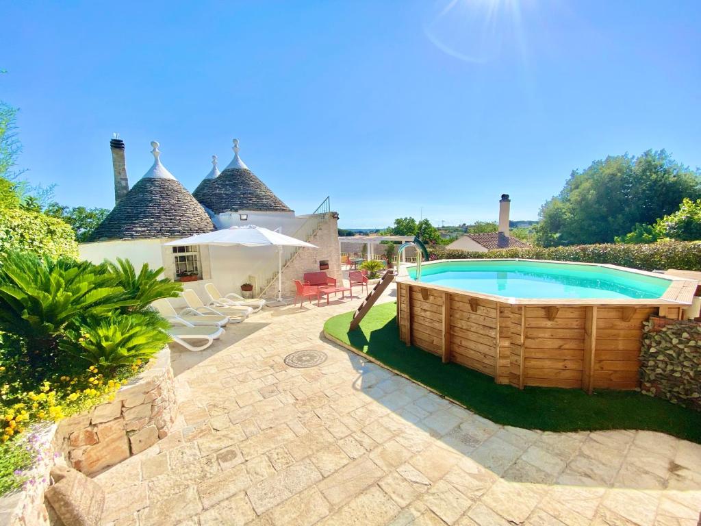 a garden area with a pool and a wooden fence at Trulli Fenice in Martina Franca