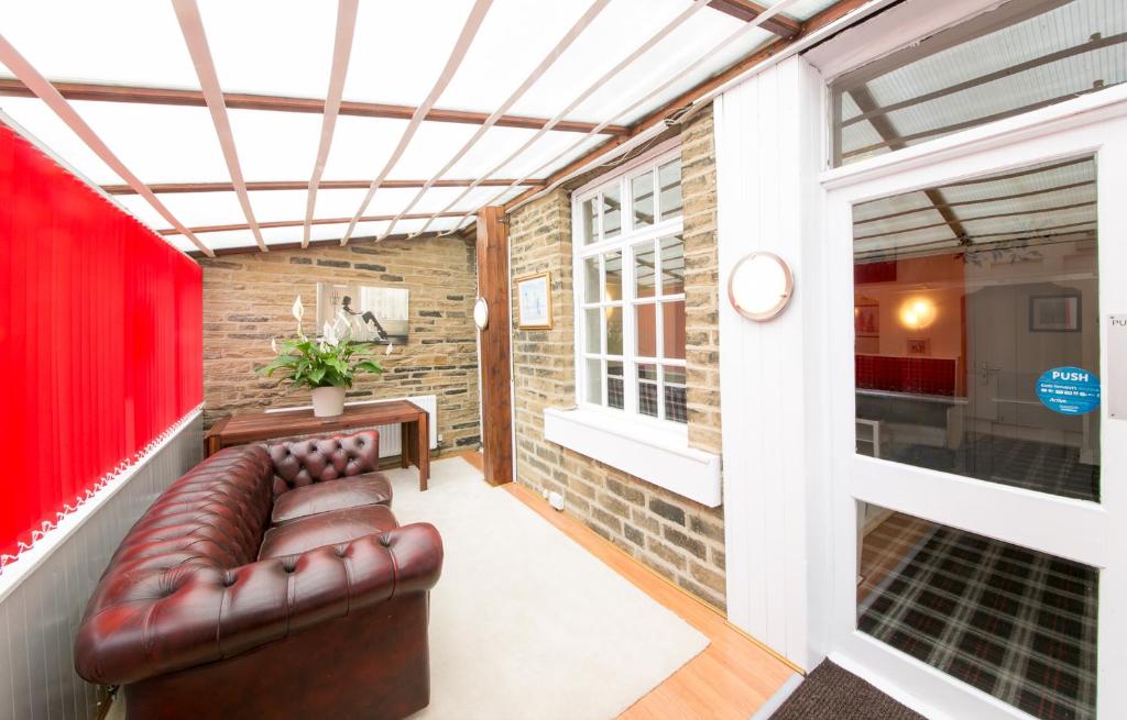 a living room with a leather couch and a window at Homeleigh Hotel in Bradford