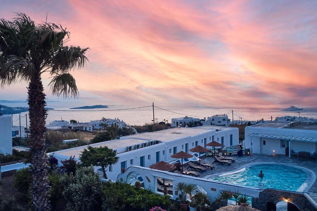 Blick auf ein Resort mit einem Pool und einer Palme in der Unterkunft Sofia Village in Mykonos Stadt