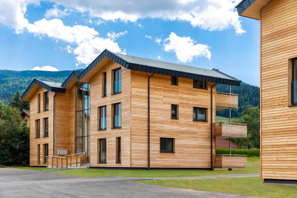 ein großes Holzgebäude mit schwarzem Dach in der Unterkunft Kreischberg Suites by ALPS RESORTS in Sankt Lorenzen ob Murau