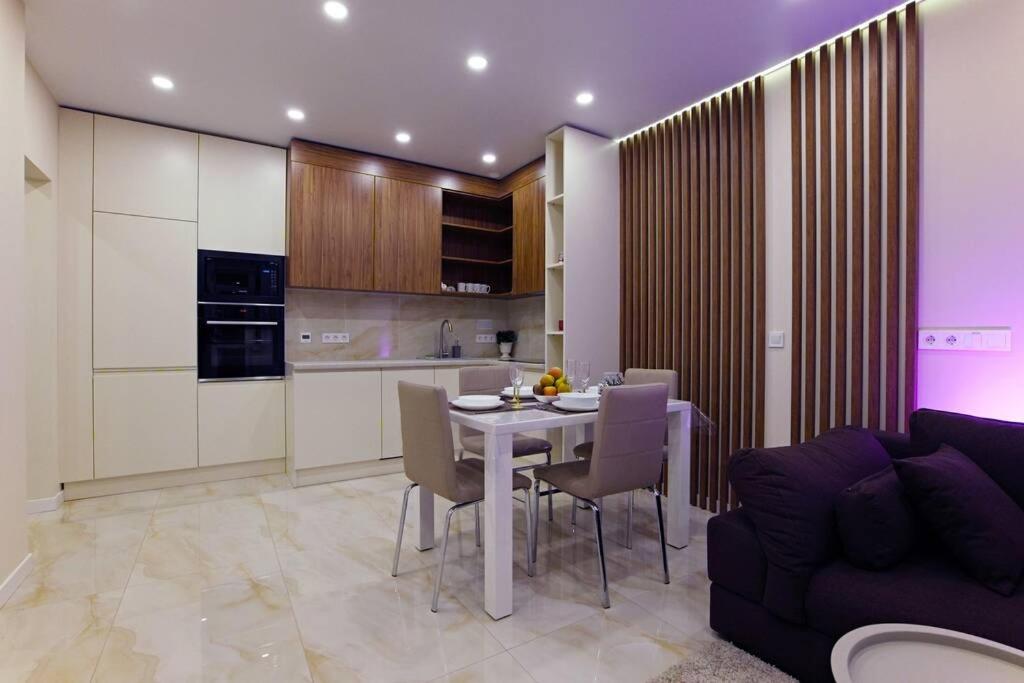a kitchen and dining room with a table and a couch at VICTORY deluxe 2 room apartment in Kyiv