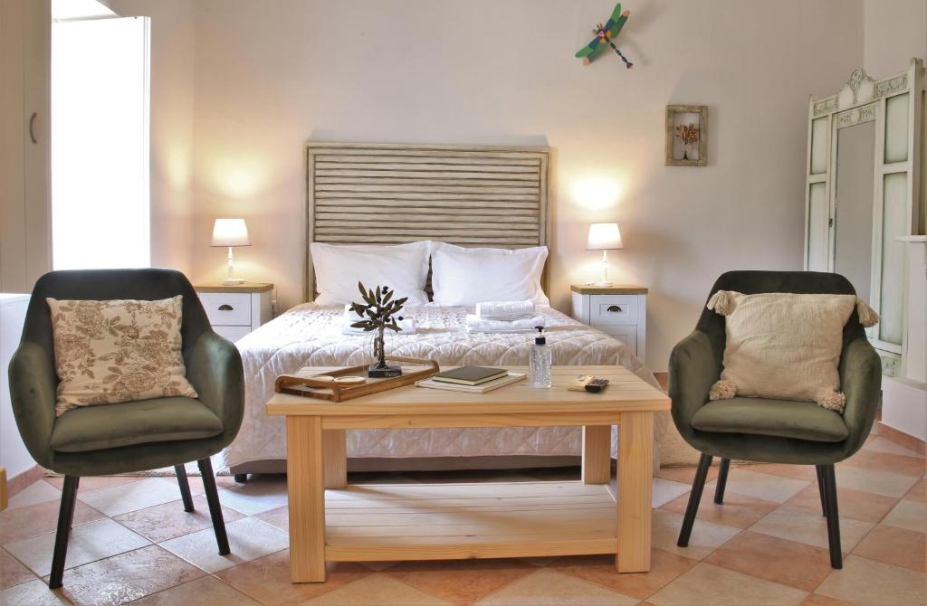 a bedroom with a bed and two chairs and a table at For4 Seasons Home 2 - by Avelink in Spata