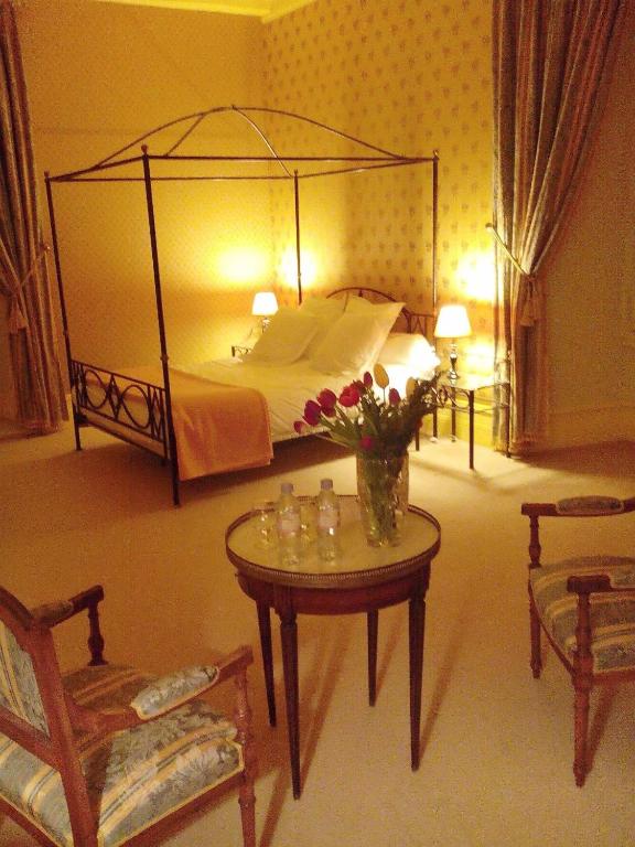 - une chambre avec un lit et une table fleurie dans l'établissement Château de Ré, à Le Petit-Pressigny