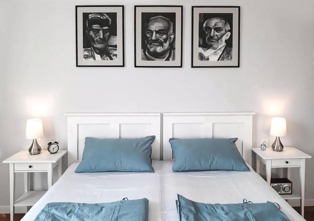 um quarto com uma cama com três fotografias na parede em Hangers em Turda
