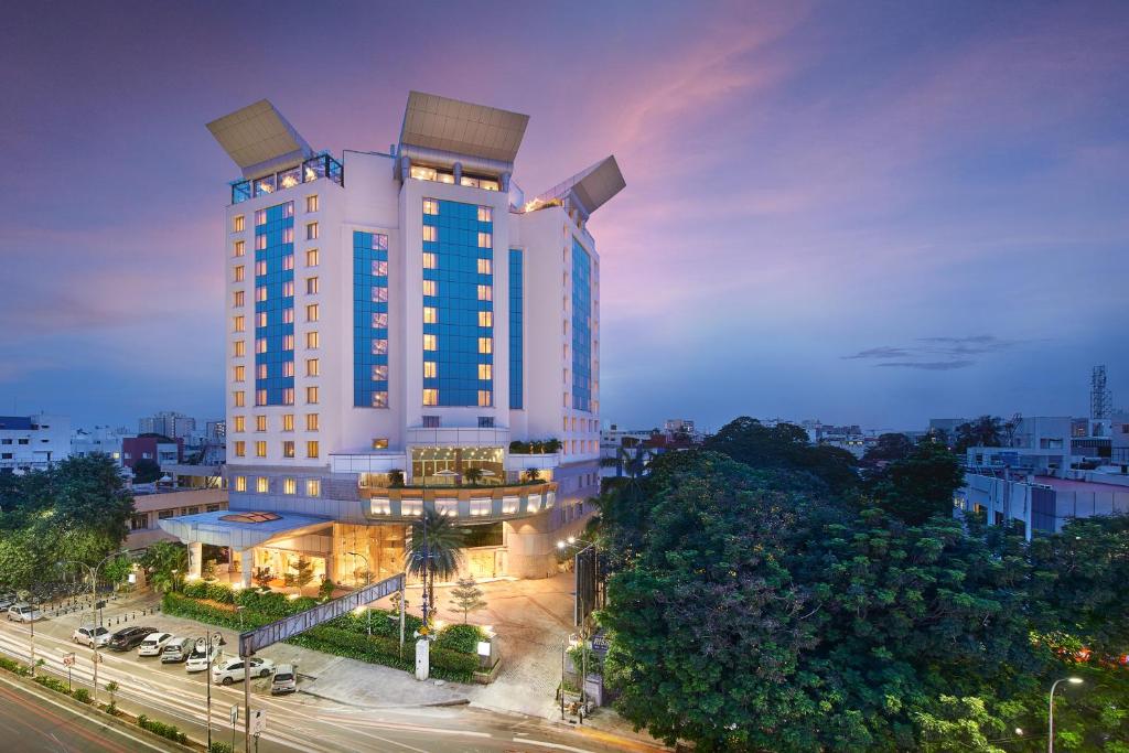 a tall white building with blue windows on a city street at The Accord Metropolitan in Chennai