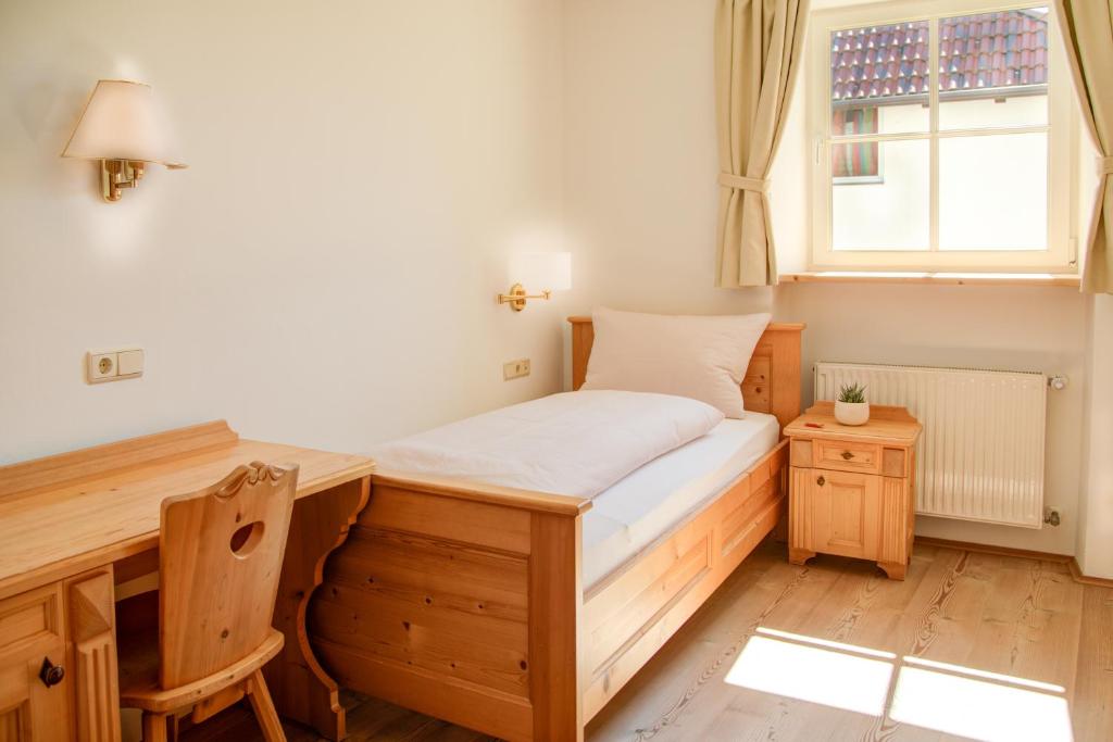 uma cama num quarto com uma secretária e uma janela em Gasthof Wunder em Auna di Sotto