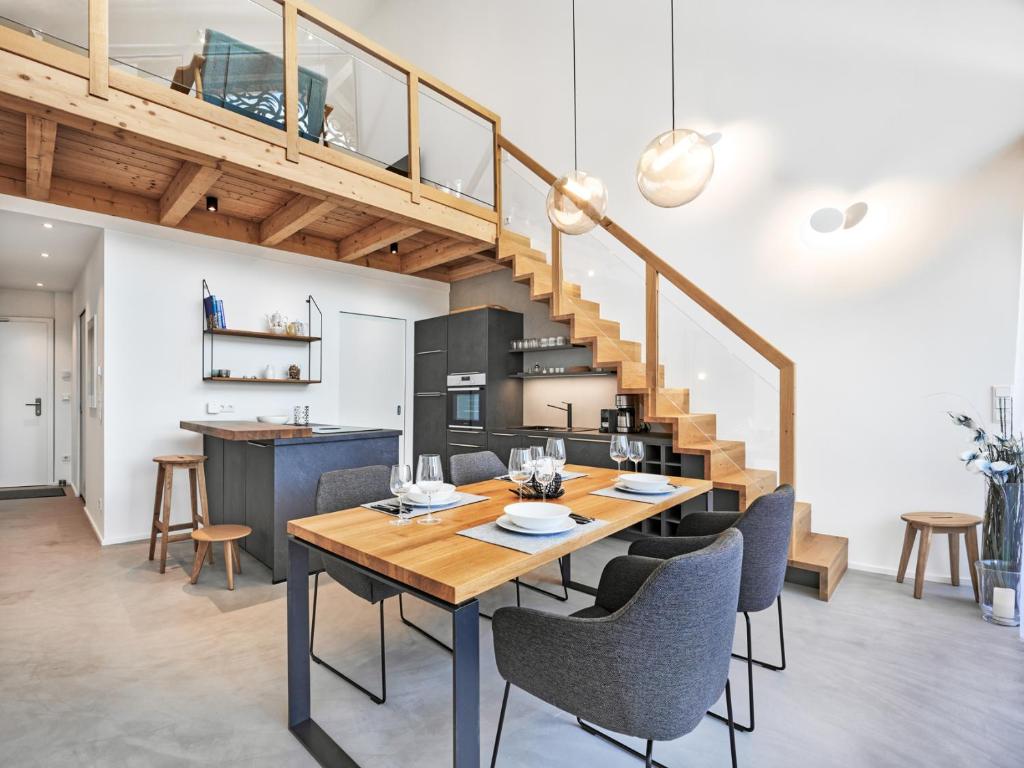 a dining room with a table and chairs and a staircase at Galeriewohnung Hechelstein 105 in Tauplitz