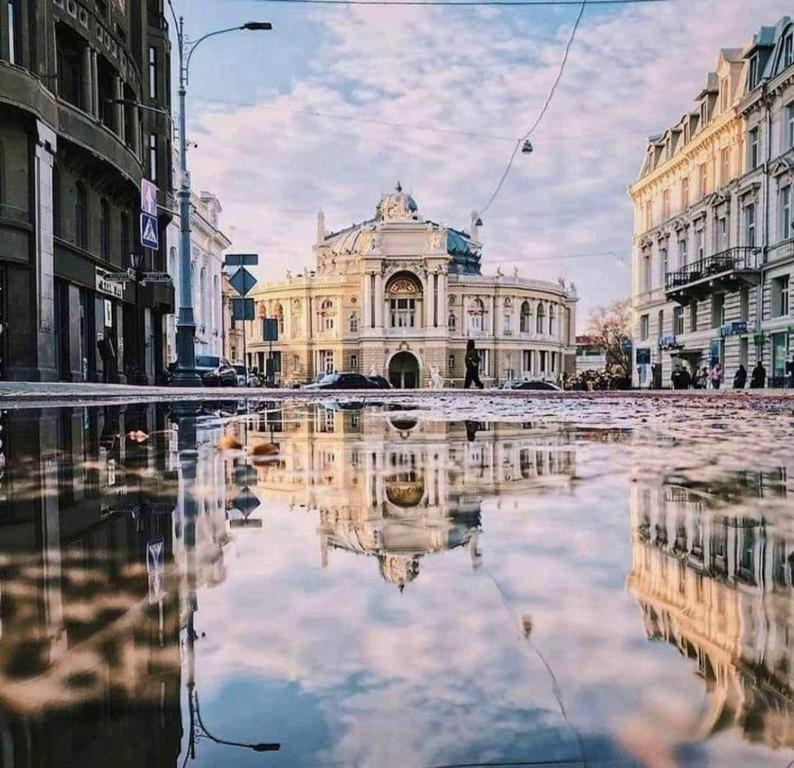 un bâtiment dans une rue de la ville avec sa réflexion dans l'eau dans l'établissement Lift Hotel Boutique, à Odessa