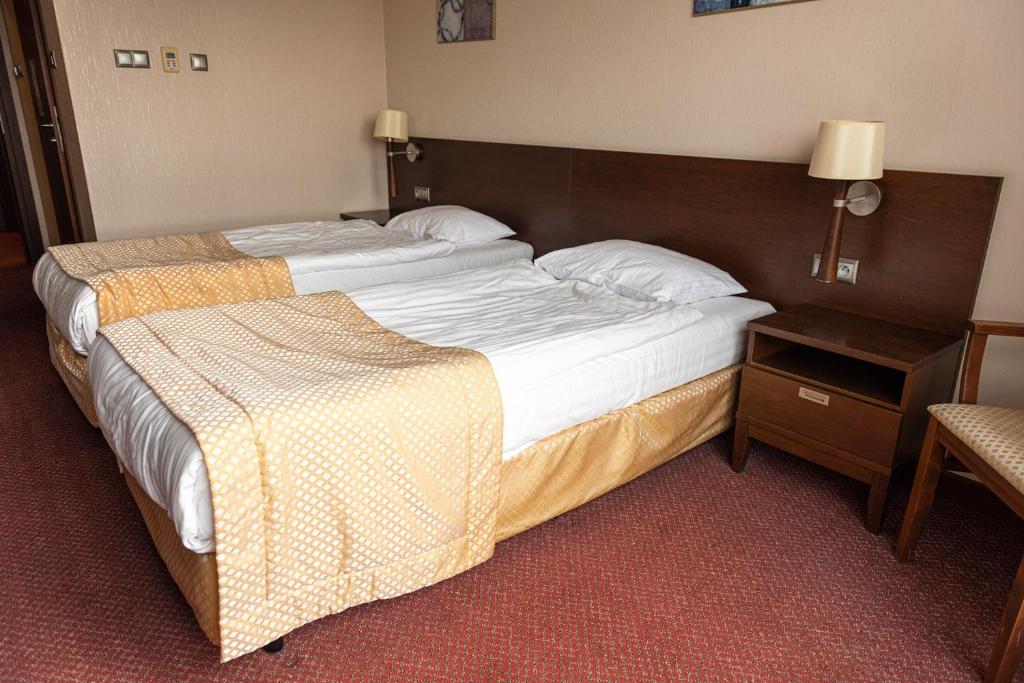 a hotel room with a large bed and a table at Hotel MOP Oleśnica Mała in Oleśnica Mała