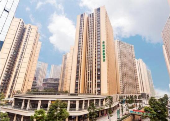 un grand bâtiment dans une ville avec de grands bâtiments dans l'établissement GreenTree Inn Chengdu high-tech Development West Zone Shidai Tian Street Express Hotel, à Chengdu