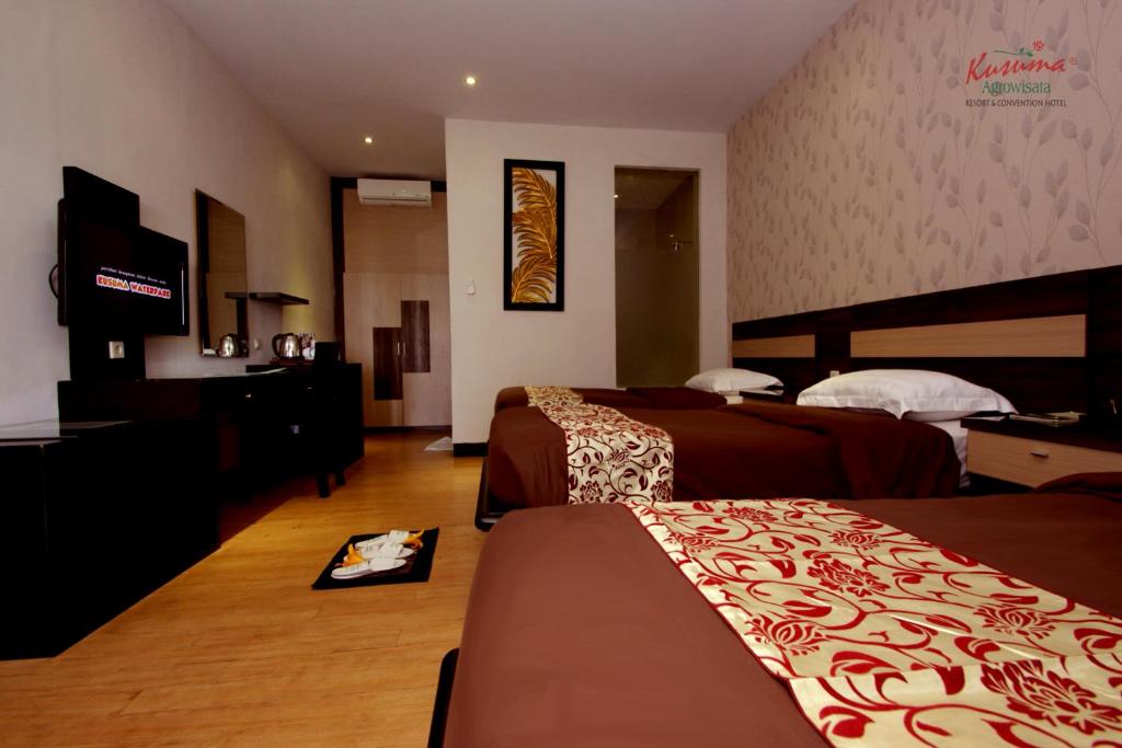 Postel nebo postele na pokoji v ubytování Kusuma Agrowisata Resort & Convention