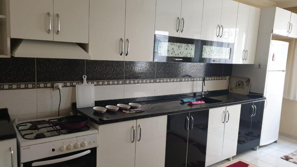 eine Küche mit weißen Schränken und einer schwarzen Arbeitsplatte in der Unterkunft Sky Ankara Big Suit Home in Ankara