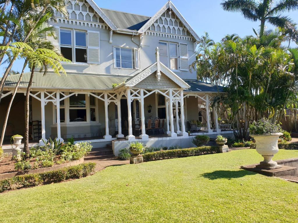 a white house with a lawn in front of it at St. Annes Guest House in Durban