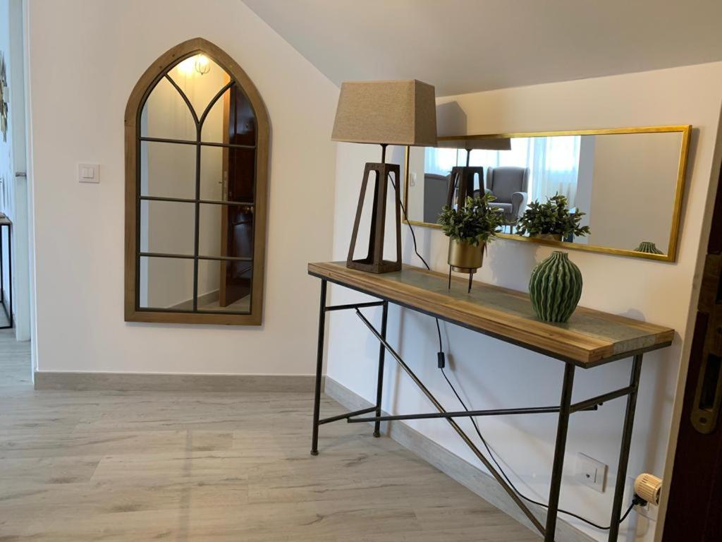 una stanza con un tavolo con uno specchio e un cactus di Apartamento Los Arcos a Llanes