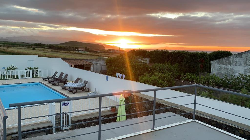 a villa with a swimming pool and a sunset at Pôr do Sol in Ribeira Grande