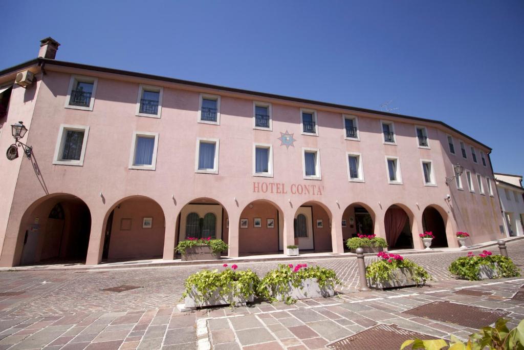 a large building with flowers in front of it at Hotel Contà Taste The Experience in Pieve di Soligo