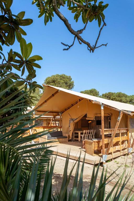 un gran edificio con techo en una playa en HolaCamp Sitges Garrofer, en Sitges
