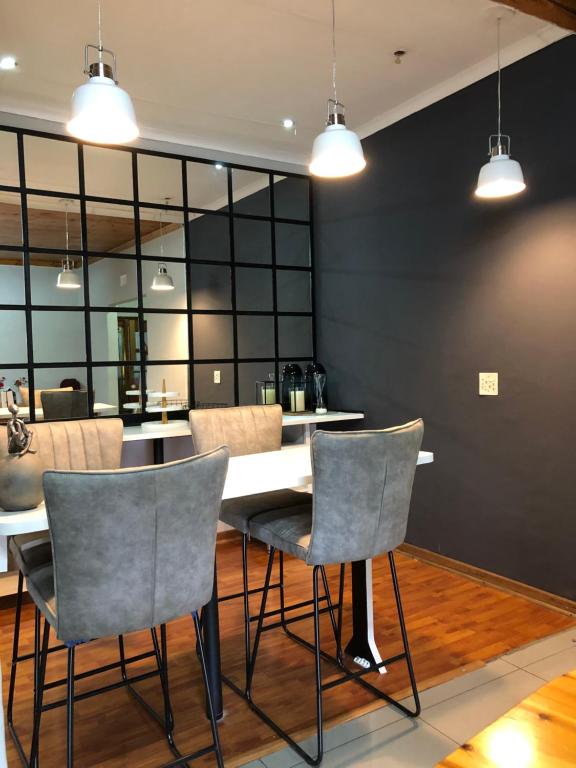 a dining room with a white table and chairs at VnA Guesthouse in Newcastle