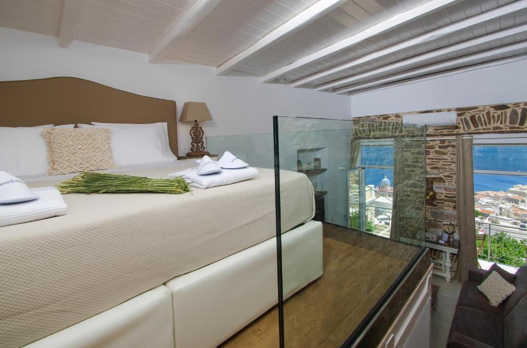 a bedroom with a large bed and a window at TOP SUITES in Ermoupoli