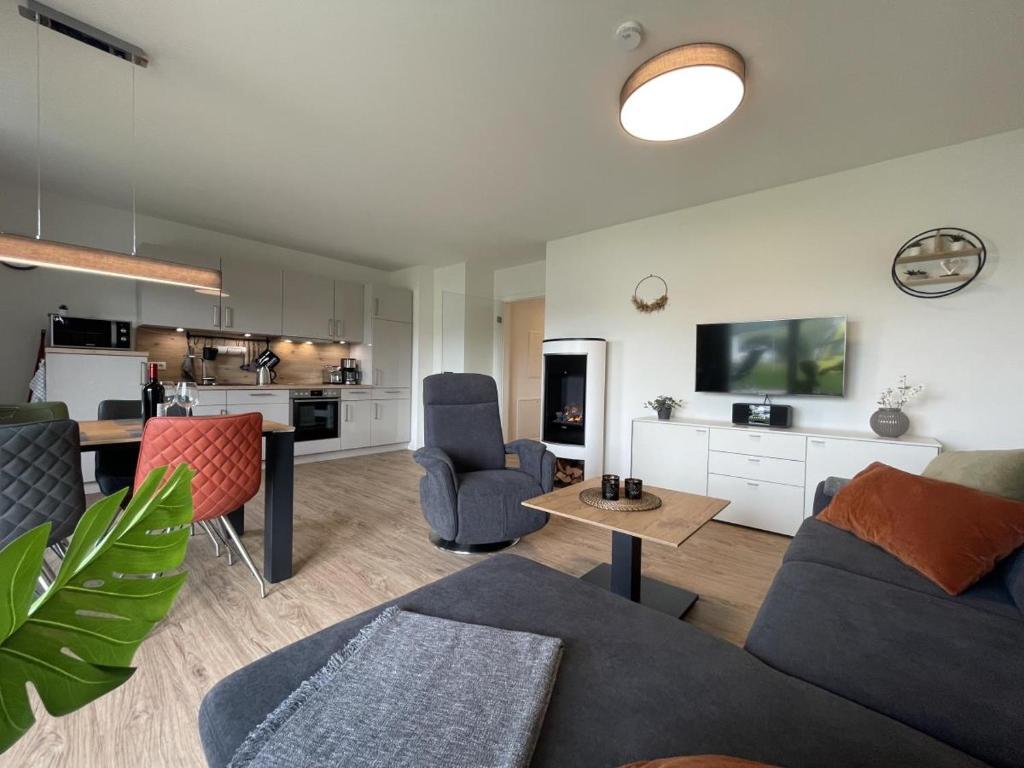 Il comprend un salon avec un canapé et des chaises ainsi qu'une cuisine. dans l'établissement Sonnenweg 46 - SEESTERN, à Heringhausen