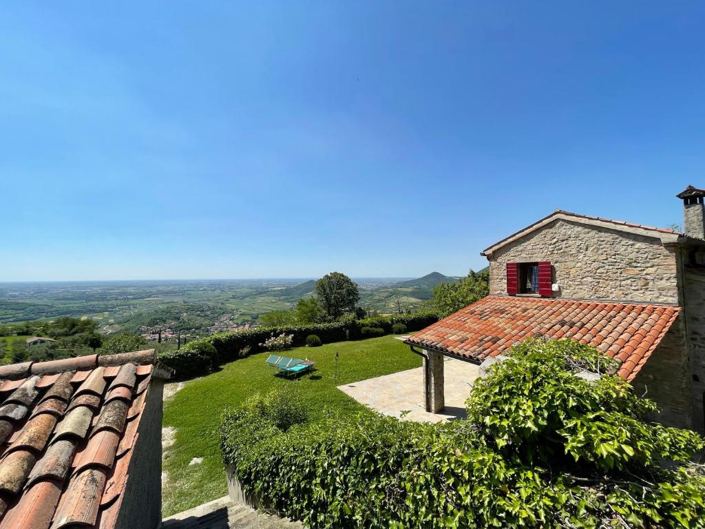 ein Haus mit einem roten Fenster und einem Dach in der Unterkunft Villa degli ulivi by Holiday World in Arqua Petrarca