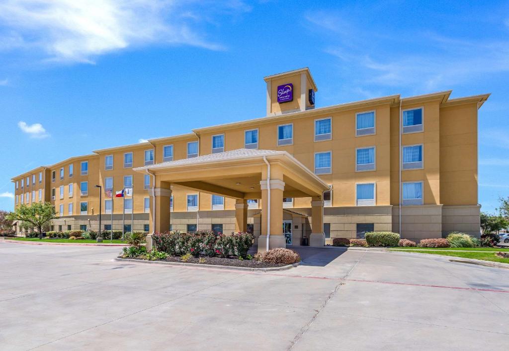 a hotel building with a clock tower on top of it at Sleep Inn & Suites Midland West in Midland