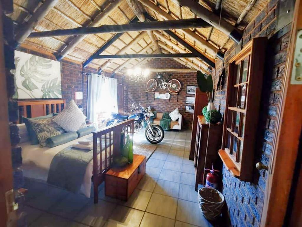 a room with a bed and a motorcycle in it at Grotto to Gravel in Magaliesburg