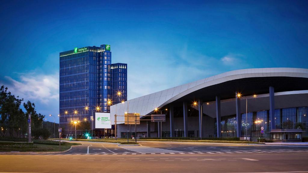 a large building with a tall building in the background at Holiday Inn Chengdu Qinhuang, an IHG Hotel in Chengdu