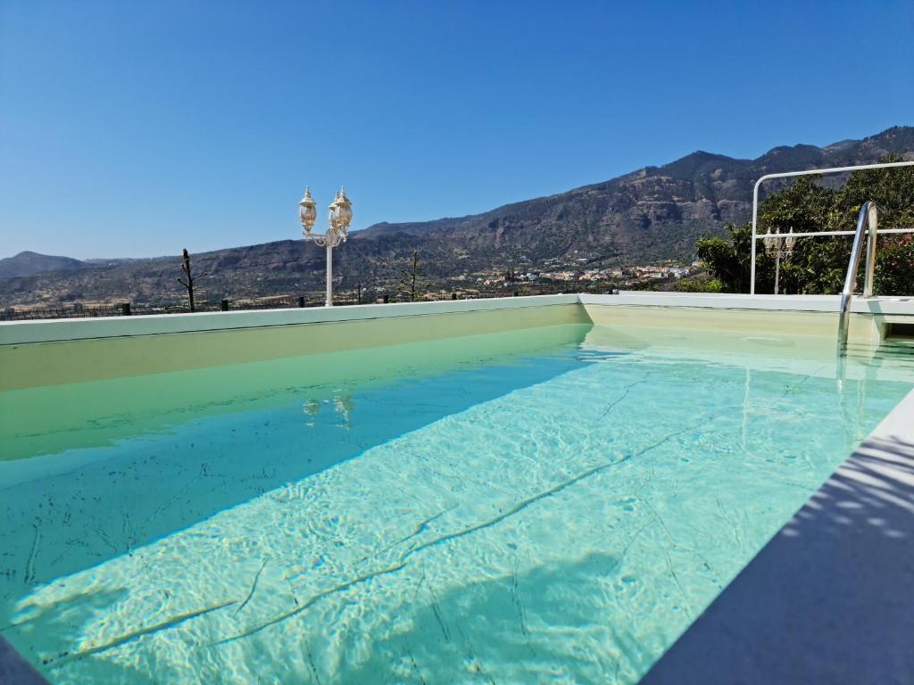 uma piscina com água azul e montanhas ao fundo em Holiday Home Hemi em Valsequillo