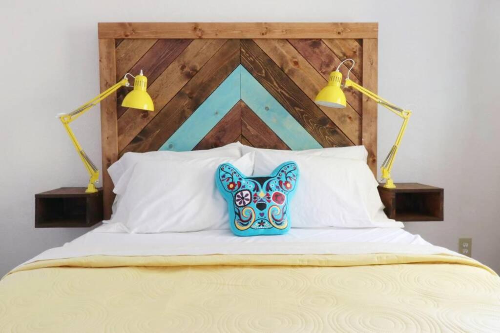 Una cama con dos luces encima. en New! JT SUNSHINE HOUSE Cozy, Artsy & Comfy, Dog Friendly, 3BD en Joshua Tree