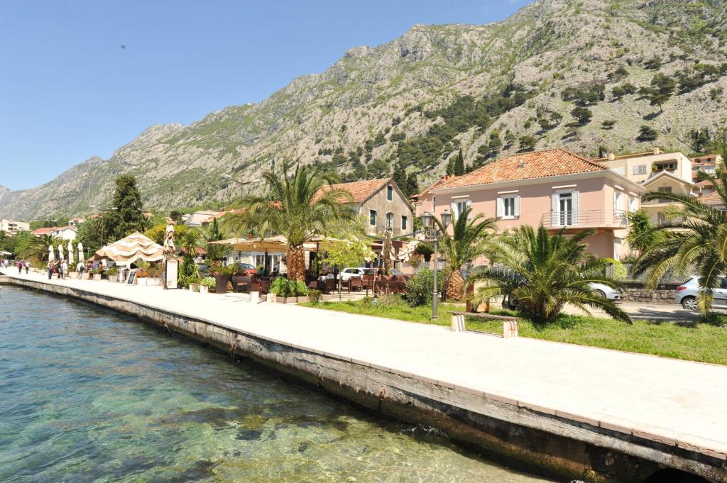 un puente sobre un cuerpo de agua con casas y montañas en Apartments Marilu, en Kotor