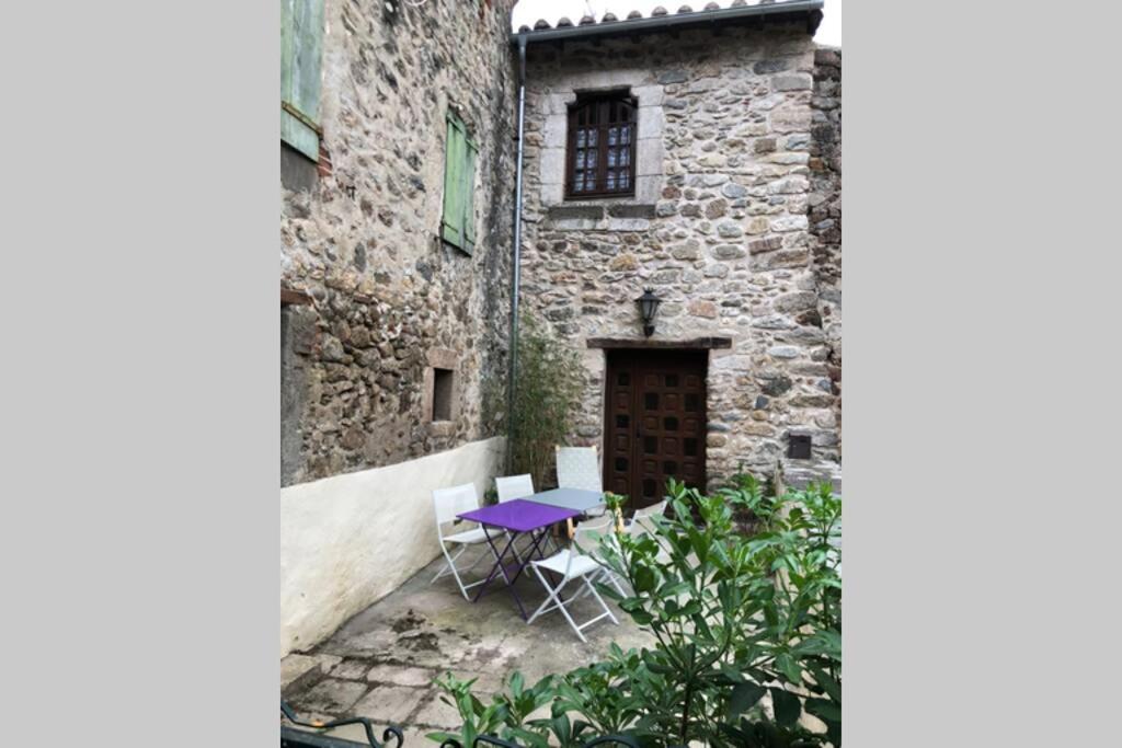 einen lila Tisch und Stühle vor einem Gebäude in der Unterkunft Les Maisons du Conflent, maisons familiales en pierre au coeur des remparts in Villefranche-de-Conflent