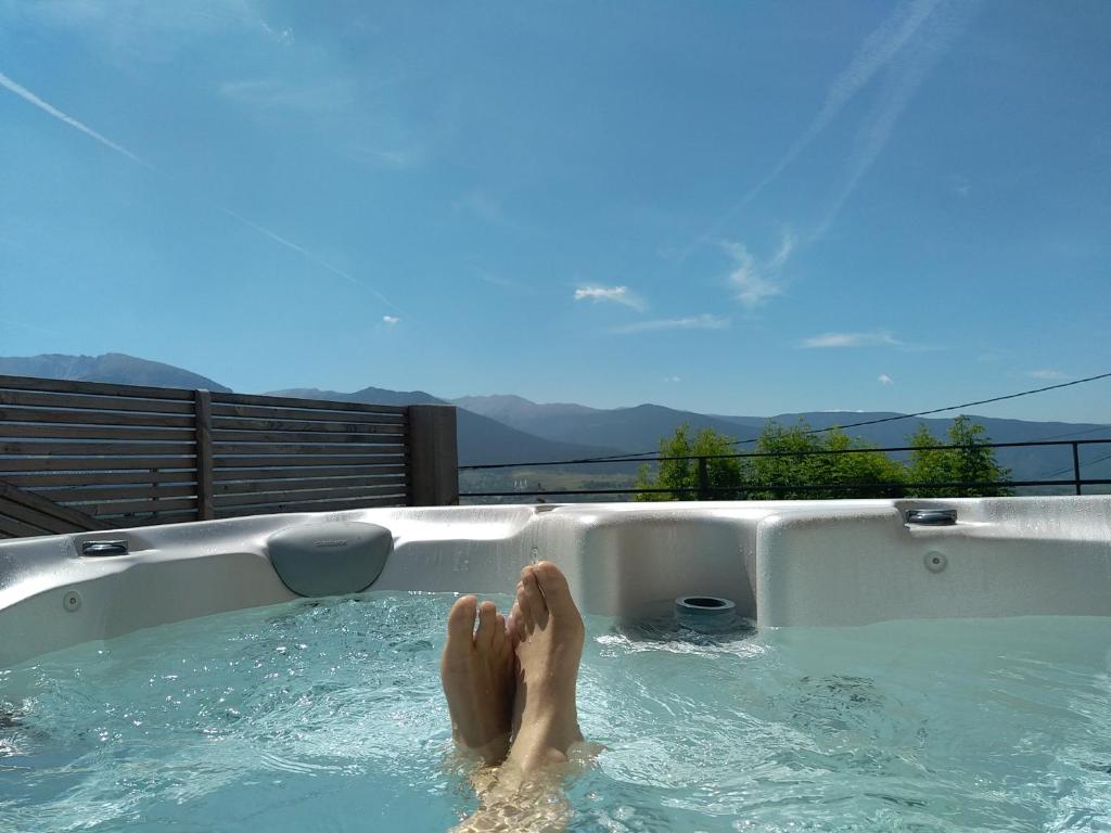 una persona en una bañera con sus pies en ella en Chalet Spa Fora Pista en Bolquere Pyrenees 2000