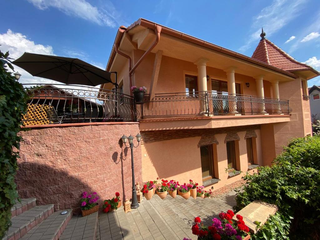 ein Haus mit einem Balkon und Blumen in Töpfen in der Unterkunft Luxusný apartmán Kanianka, Bojnice a okolie in Kanianka