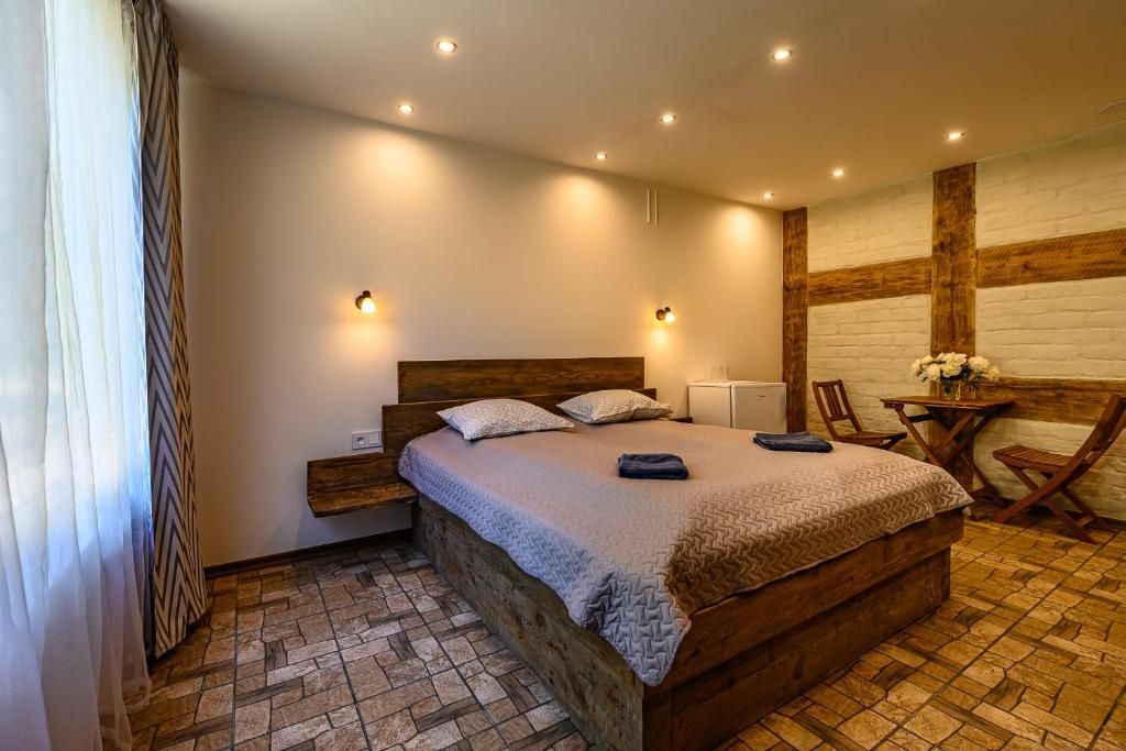 a bedroom with a large bed and a table at Place near beach in Pērkone