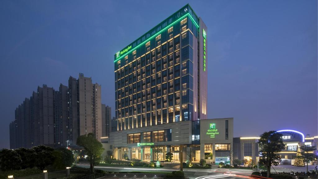 un edificio alto con luz verde. en Holiday Inn Shunde, an IHG Hotel en Shunde