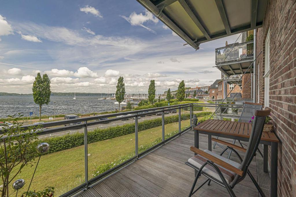 a balcony with a table and a view of the water at fewo1846 - MeerFreiRaum in Flensburg