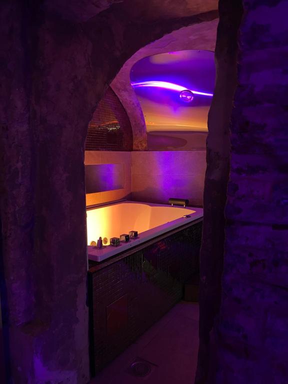 baño con bañera con iluminación púrpura en Private Room & Spa avec jacuzzi privatif en Lille