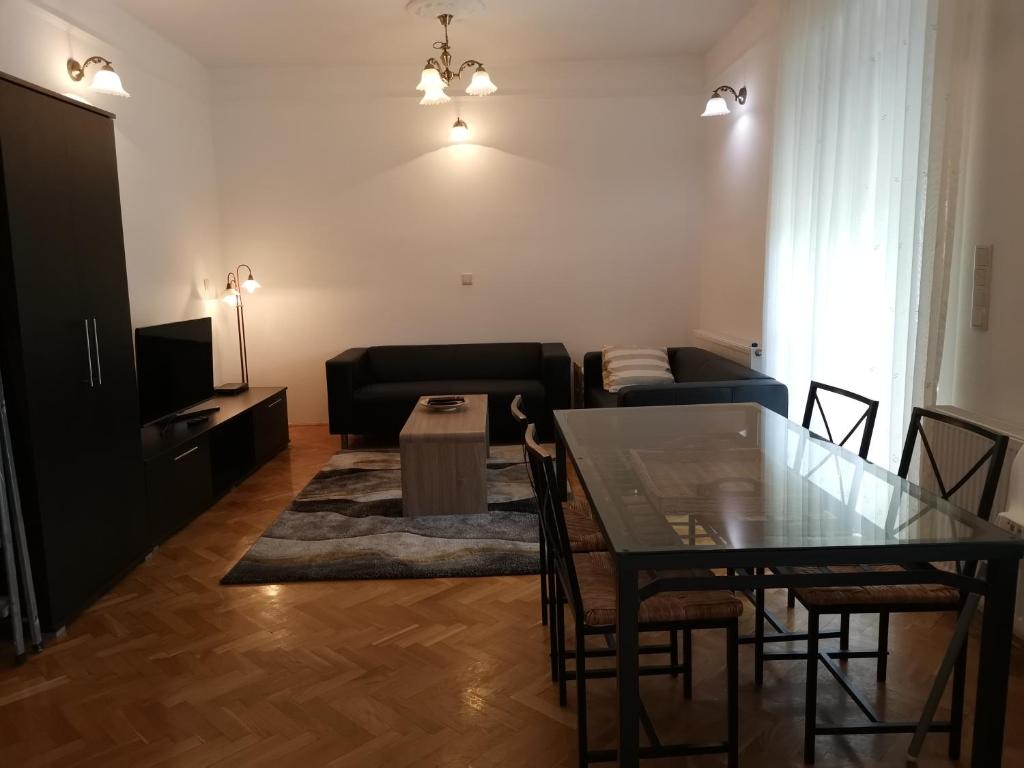 sala de estar con mesa y sofá en Sugár apartman, en Debrecen