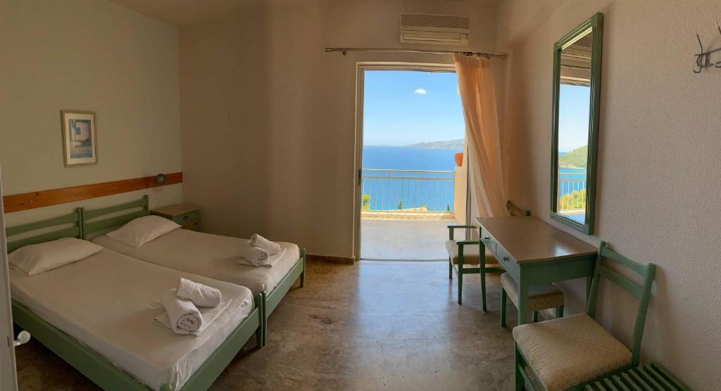 a room with two beds and a view of the ocean at Fedra Apartments in Poros