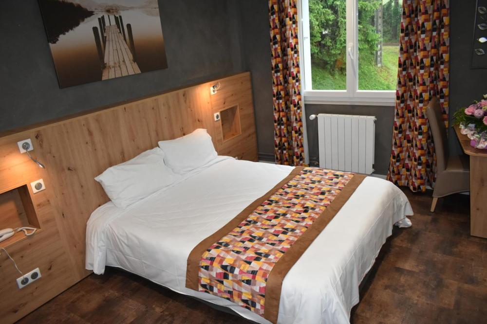 Postel nebo postele na pokoji v ubytování Logis Hôtel Beau Site