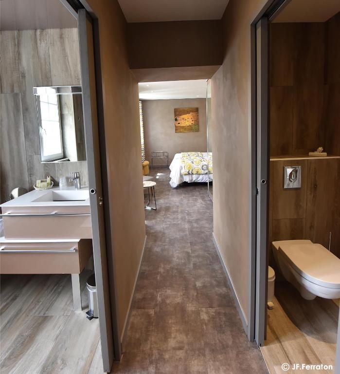 a bathroom with a sink and a bed in a room at Logis Hôtel Beau Site in Loubaresse