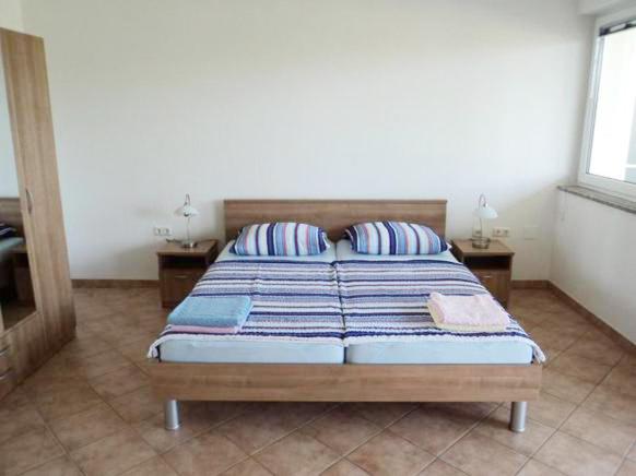 - une chambre avec un lit et 2 oreillers dans l&#39;établissement Apartments Delfini, à Sveti Filip i Jakov