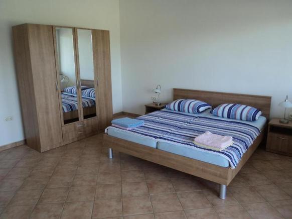 - une chambre avec un grand lit et un miroir dans l&#39;établissement Apartments Delfini, à Sveti Filip i Jakov