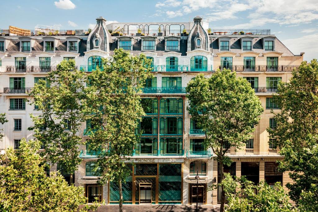 apartamentowiec z drzewami przed nim w obiekcie Kimpton - St Honoré Paris, an IHG Hotel w Paryżu