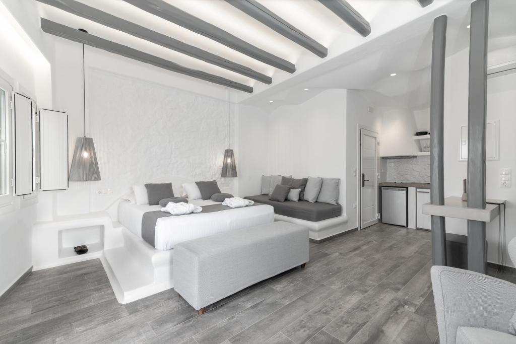 un soggiorno bianco con divano e letto di El_Puerto Luxury port suites a Naxos Chora